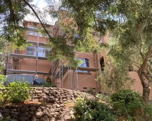 Residential hillside home with exterior scaffolding system installed by Glendale Scaffolding Rental for stucco renovation project